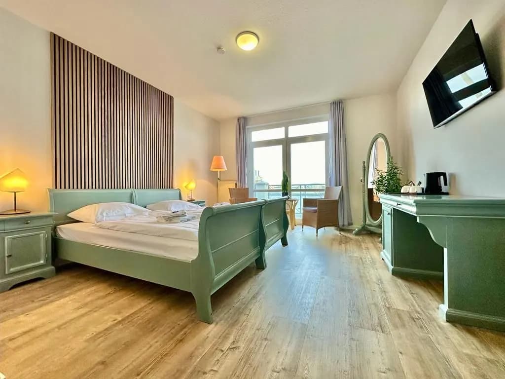 Zimmer mit Holzboden und Schreibtisch im Gästehaus Weserblick